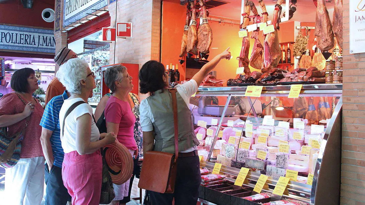Stall of Iberian ham and cheeses at Mercado de Triana during a morning Seville food tour of the market