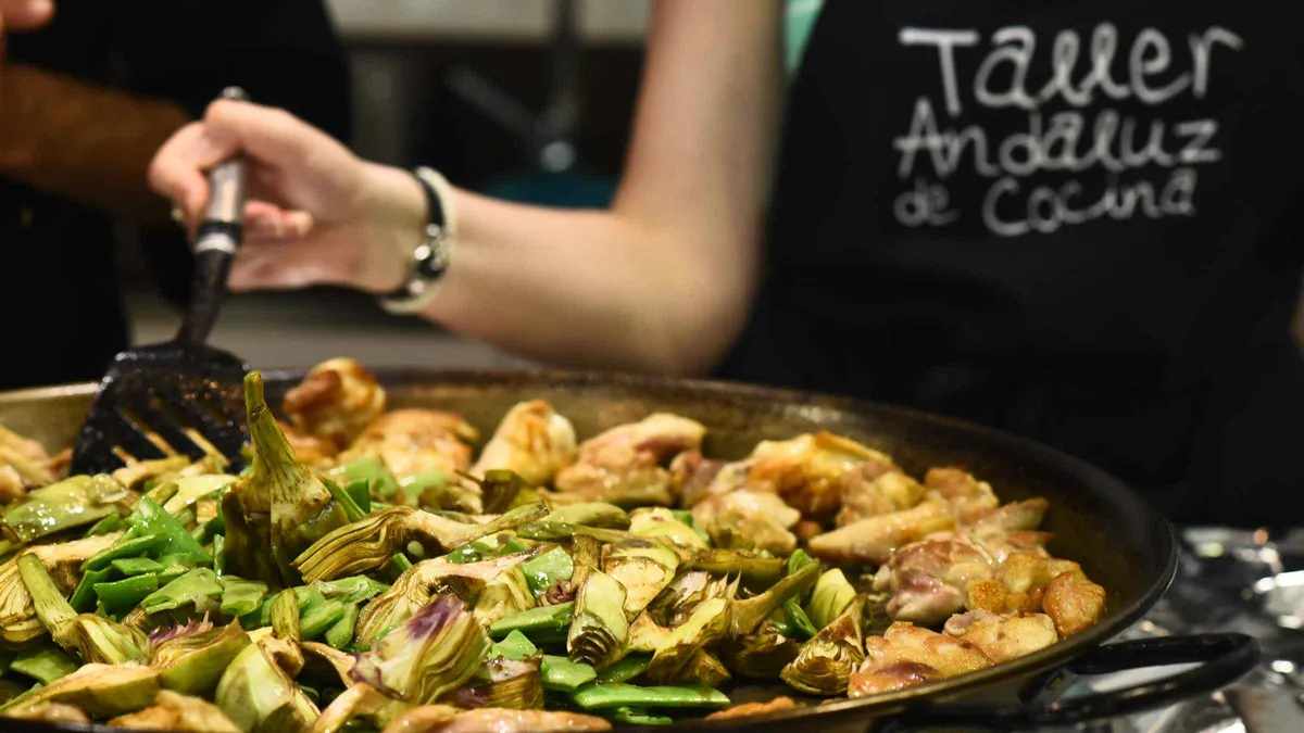 Paella pan and chopped vegetables at a cooking class inside Mercado de Triana on a Seville food tour and cooking experience