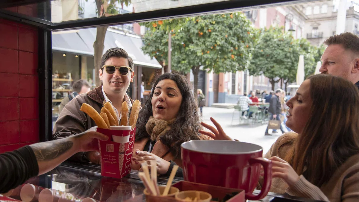 Small group tasting croquetas and jamon iberico at a bar counter on a Seville food tour through the old town
