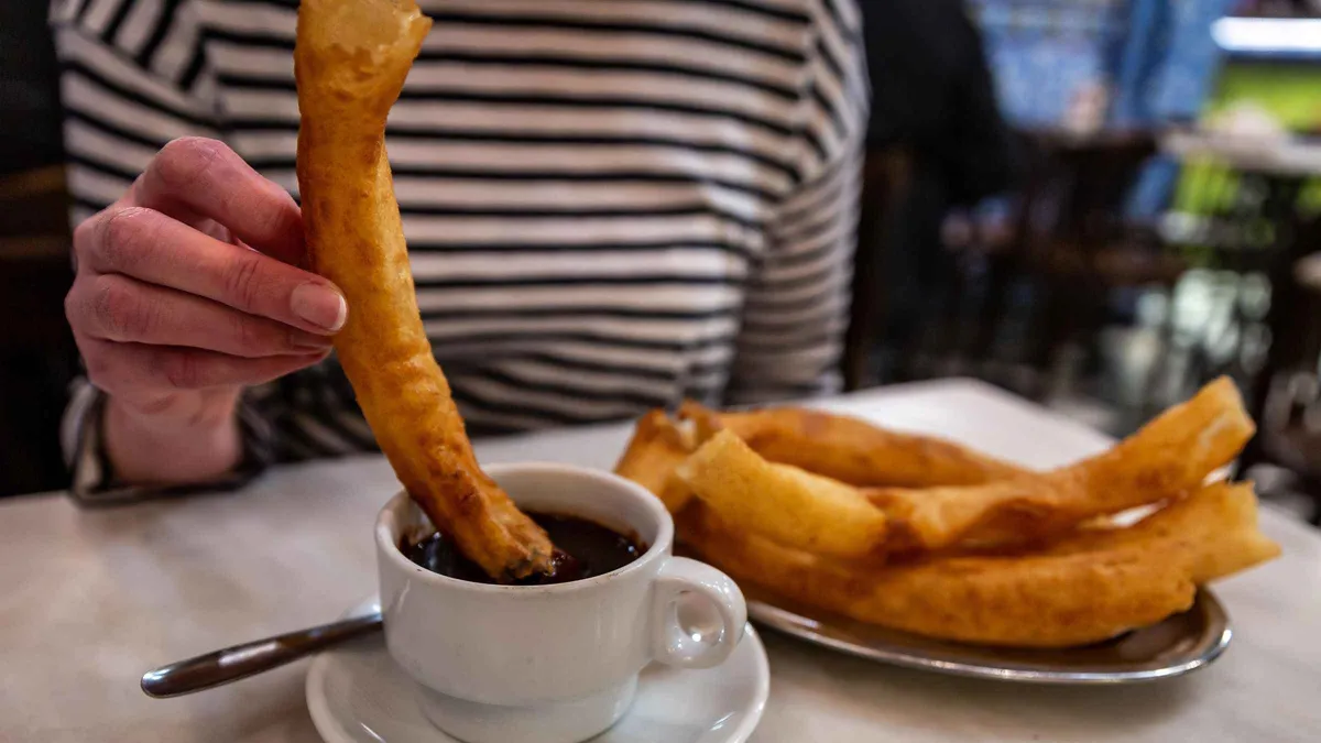 Churros with hot chocolate and a plate of Iberian ham on a Seville food tour through the Old Town